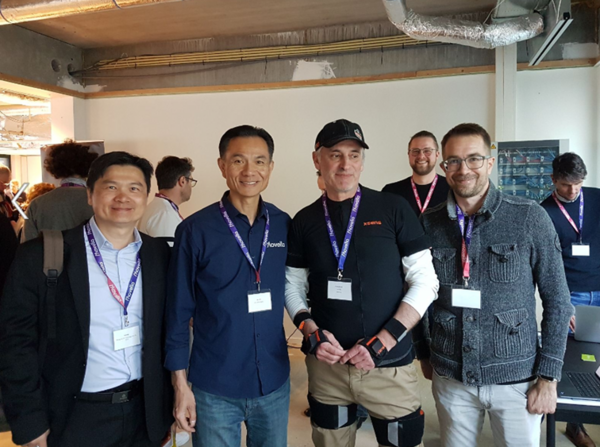 Gruppenbild von zwei Mitarbeitern von Movella aus dem asiatischen Raum sowie 2 Mitarbeitern von scalefit aus Deutschland im Rahmen des Movella Partner Summit 2023. Eine der Personen trägt einen XSENS Motion Capture Anzug, um Bewegungen digital zu erfassen
